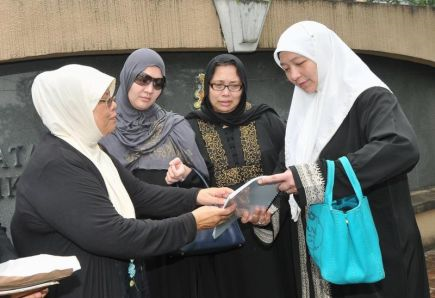 Peguam Syariah, Kamar Ainiah Kamaruzaman (kiri), melihat dokumen afidavid bersama anak-anak bekas Sultanah Johor, Tuanku Zanariah Tunku Ahmad iaitu Tunku Masera (dua dari kiri), Tunku Noraini (tiga dari kiri) dan Tunku Muna di luar Mahkamah SYariah Johor Baru di sini. foto TheStar ABDUL RAHMAN EMBONG