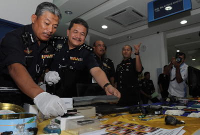 Pemangku Ketua Polis Pulau Pinang Datuk Abdul Rahim Jaafar (kiri) memerhatikan pembaca magnetik (ATM Skimmer) dan pencuri nombor pin kad akaun bank menggunakan kamera digital kecil yang ditunjukkan oleh Ketua Jabatan Siasatan Jenayah Komersial (JSJK) negeri, Asisten Superitendan Roslee Chik semasa mengadakan sidang akhbar di Ibupejabat Polis Daerah Seberang Prai Selatan. -fotoBERNAMA