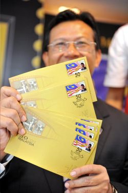 Shabery Cheek menunjukkan setem 50 Tahun Malaysia dan sampul surat Hari Pertama.- FotoBERNAMA