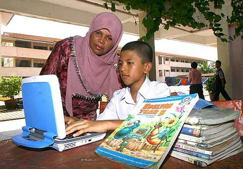 Pelajar darjah 5 Sek. Keb. kompleks Gong Badak, Kuala Terengganu, Azmarul Mizan Nurhakim Abd Aziz menunjukkan komputer riba e-Book kepada ibunya, Umi Kalsom Arif,49 selepas Majlis  Majlis Penyerahan e-Book Sekolah-Sekolah Rendah DUN Seberang Takir & DUN Bukit Tunggal. -foto The Star oleh M. AZHAR ARIFF