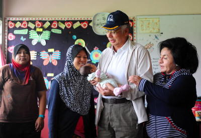 MESRA…Perdana Menteri Datuk Seri Najib Tun Razak bersama isteri Datin Seri Rosmah Mansor mengendong bayi berusia 21 hari Nurul Hana Mohd Hazdli sambil diperhati oleh ibunya Intan Norsuaidah Abdul Halim (dua, kiri) ketika melawat Pusat Pemindahan Banjir di Sekolah Menengah Sains Sultan Ahmad Shah dekat Pekan, Khamis. Beliau dan isteri meluangkan masa melawat tiga pusat pemindahan banjir iaitu dua di Pekan dan satu di Rompin bagi mengetahui perkembangan terkini banjir di Pahang. -fotoBERNAMA 