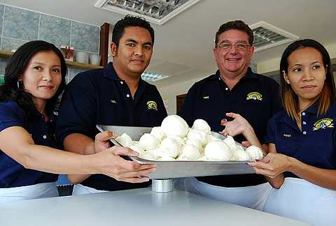 Pemilik Friendly Farms Norzana Ghazali, 25, (kanan), suaminya Michael Bruschi, 53 (dua dari kanan) dan staf mereka menunjukkan keju mozzarella yang dihasilkan pada hari itu baru-baru ini di Langkawi. foto Bernama