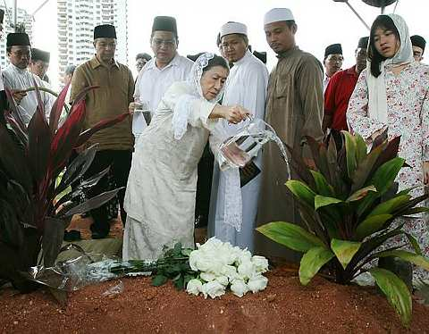 Puan Sri Salbiah Abdul Hamid, menyiram air ke pusara Allahyarham suaminya, Tan Sri Mohamed Rahmat di Tanah Perkuburan Islam Bukit Kiara hari ini. -Foto The Star oleh SHAARI CHE MAT