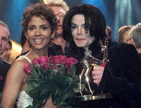 Raja Pop, Michael Jackson (kanan) mempamerkan Anugerah Golden Bambi yang dimenanginya semasa majlis penyampaian anugerah 'Bambi Award' di Berlin pada 21 November 2002. Bersamanya ialah 
aktres, Halle Berry yang menerima anugerah Bambi dalam kategori Filem Antarabangsa. -foto AP