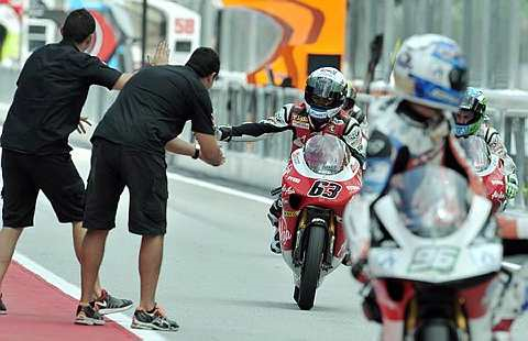 SYABAS... Rakan sepasukan pelumba AirAsia-SIC-Ajo, Zulfahmi Khairuddin memberi tepukan tahniah selepas menamatkan perlumbaan 125cc pada tempat ketujuh sempena perlumbaan Shell Advance Malaysian Motocycle Grand Prix di Litar Antarabangsa Sepang di sini hari ini. -foto BERNAMA