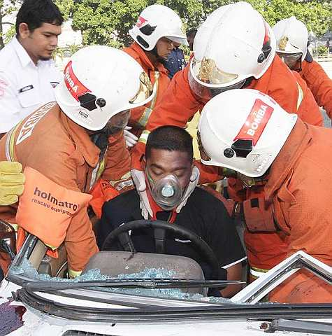 Anggota Bomba dan Penyelamat cuba menyelamatkan mangsa yang tersepit ketika kemalangan pada simulasi penyelamatan kemalangan jalan raya sempena majlis pelancaran 'Ops Raya 2009' anjuran Jabatan Bomba dan Penyelamat di Plaza Tol Sungai Besi di Kuala Lumpur, hari ini. -foto Bernama