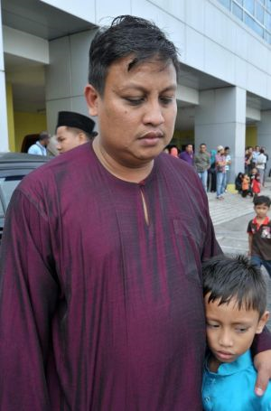 Irwan Kamaruddin, 37 (kiri) dan anak lelakinya Mohd Hazimy Irwan, 8, kelihatan sayu ketika menunggu jenazah isteri Norazita Abu Talib pegawai Am Bank yang mati di tembak pengawal keselamatan di AmBank USJ Subang Jaya untuk di bedah siasat di Hospital Serdang, Selangor pada Khamis. Foto ihsan UTUSAN MALAYSIA