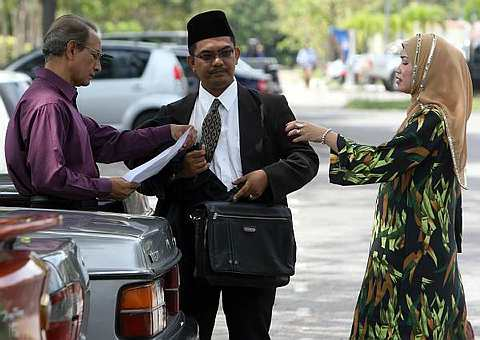 SITI Fatimah Yacob bercakap dengan suaminya, rakyat Pakistan, Muhammad Abdullah di pekarangan Mahkamah Syarikah Kuala Terengganu Syariah hari ini. foto The Star oleh M. AZHAR ARIF