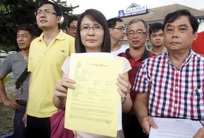 Bekas Adun Teratai Jenice Lee (tengah) menunjukan laporan polis terhadap Ahli Parlimen Cheras Tan Kok Wai di Balai Polis Pandan Indah, Rabu. -fotoBERNAMA