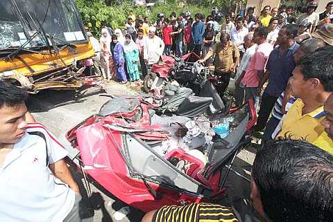 REMUK ... Sebuah bas dan kereta jenis Proton Iswara bertembung di kilometer 7, Jalan Kangar- Padang Besar ketika dalam perjalanan pulang daripada majlis akad nikah di Kangar, semalam. -foto Bernama