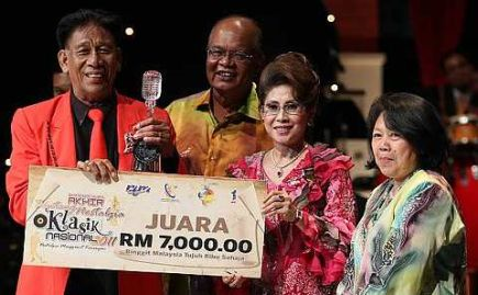 Datin Seri Masnah Rais dan Datuk Sri Kamaruddin Siaraf menyerahkan hadiah kepada juara Bintang Nostalgia Klasik Nasional (BNKN) 2011, Baharudin Bab di Auditorium Perdana, Angkasapuri, Kuala Lumpur, Sabtu. - Foto GLENN GUAN