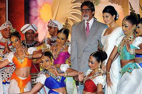 Pelakon Bollywood dan duta International Indian Film Academy (IIFA), Amitabh Bachchan bergambar bersama penari tradisional dari Sri Lankan di Colombo pada 20 April 2010. - Foto AFP