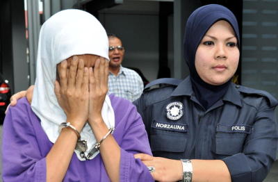 Pembantu rumah, Enong Nur Sukma, 41,(kiri), diiringi anggota polis, dihadapkan di Mahkamah Sesyen di Kota Baharu, Khamis, atas pertuduhan mendera anak majikannya yang berusia 15 bulan dalam satu kejadian pada Sabtu lalu. Enong yang berasal dari Bandung, Indonesia bagaimanapun mengaku tidak bersalah atas pertuduhan yang dibacakan terhadapnya oleh Hakim Mahkamah Sesyen Yusuf Yunus. -fotoBERNAMA