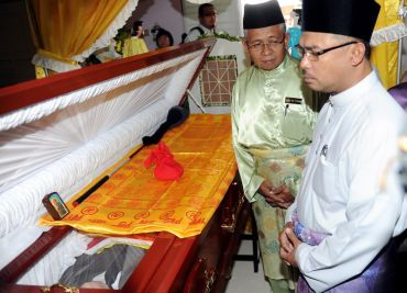 Idris Haron (kanan) melawat  mendiang Boon Huat di rumahnya di Semabok di sini,Jumaat. Turut kelihatan Datuk Yunus Husin yang juga Presiden Hoki Melaka (kiri).