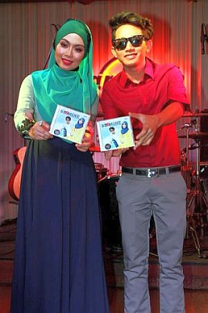 Tasha (kiri) dan Syed Shamim menunjukkan album mereka.