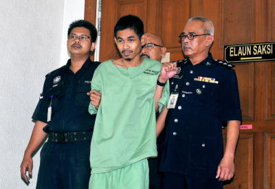 Pemandu van Muhammad Zamri Yusof, 26, (tengah) diiringi anggota polis, dihadapkan ke Mahkamah Majistret di Kuala Lumpur, Khamis terhadap pertuduhan membunuh dua lelaki dalam kejadian amuk di Stesen Transit Aliran Ringan (LRT) Taman Melati, Kuala Lumpur, 24 Oktober lalu.  -fotoBERNAMA