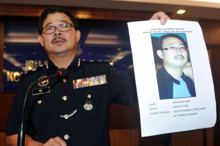 Datuk Ku Chin Wah memegang gambar suspek di ibu pejabat polis kontigen Kuala Lumpur pada Selasa. -Foto BERNAMA. 