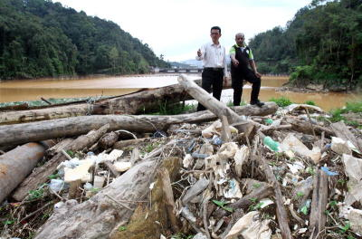 Pengurus Besar Stesen-Stesen Janaelektrik Cameron Highlands Mustafa Hashim dan Presiden Kesedaran Alam Sekitar Cameron Highlands R. Ramakrishnan menunjukkan sampah sarap dan sisa pepejal yang ditarik keluar dari Tasik Ringlet dalam sehari, yang merupakan empangan janakuasa Sultan Abu Bakar. Di belakangnya dapat dilihat pintu alur limpah empangan di mana di atasnya ialah Lembah Bertam. -foto CHAN TAK KONG