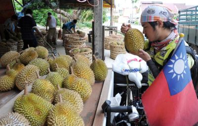 Rakyat Taiwan, Chang Chiao- Chung, 28, yang berbasikal menjelajah dunia singgah di sebuah gerai buah durian di Sungai Pinang, Balik Pulau pada Selasa untuk merasai raja buah berkenaan. -Foto BERNAMA