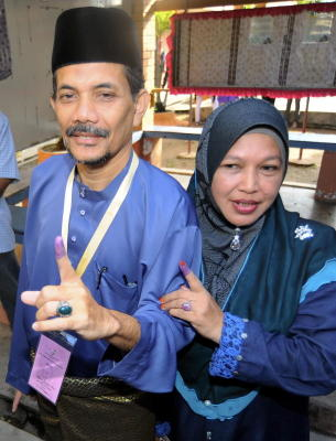 Calon Barisan Nasional Dewan Undangan Negeri (DUN) N20 Sungai Limau, Dr Ahmad Sohaimi Lazim (kiri) dan isterinya Siti Bunga Ismail menunjukan kesan dakwat kekal selepas mengundi bagi Pilihan Raya Kecil DUN Sungai Limau di Sekolah Kebangsaan Dulang di Yan, Kedah, Isnin. -fotoBERNAMA 