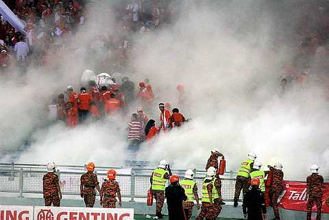 Pasukan bomba memadamkan api mercun ketika penyokong Kelantan berang pasukannya kalah kepada Negeri Sembilan, 3-1 pada perlawanan akhir Piala Malaysia di Stadium Nasional, Bukit Jalil pada 7 November 2009. -Foto BERNAMA