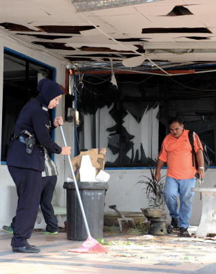 Anggota polis di Balai Polis Bukit Tengah, Bukit Mertajam membersihkan serpihan kaca dan bumbung siling yang pecah akibat satu letupan yang berlaku di balai berkenaan awal pagi Sabtu. -fotoBERNAMA 