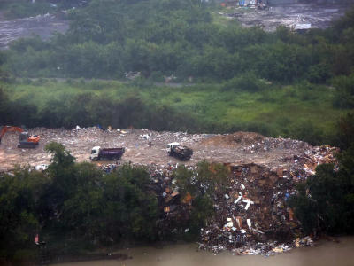 Kren dan lori sampah dapat dilihat di tebing Sungai Klang. Gambar diambil ketika aktiviti haram itu dilakukan pada sebelah petang.