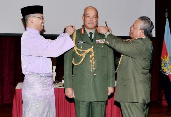 Hishammuddin (kiri) dan Zulkifli (kanan) memakaikan pangkat kepada Raja Mohamed Affandi (tengah). - FotoBERNAMA