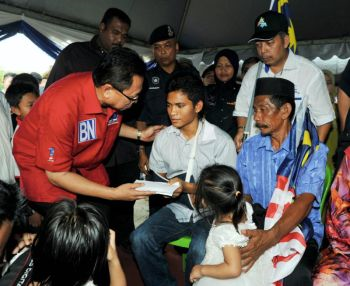 Mohd Puad menyampaikan sumbangan kepada Konstabel Mohammad Qaiyum (tengah) yang selamat pulang ke rumahnya di Kampung Bukit Kelicap, Batu Pahat, Johor. -fotoBERNAMA