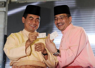 Hishammuddin bersama timbalannya Datuk Aziz Kaprawi (kiri) melihat lesen memandu masing-masing yang baru selepas melancarkannya pada Majlis Pelancaran Reka Bentuk Baharu Lesen Memandu Malaysia dan Majlis Berbuka Puasa Kementerian Pengangkutan di Jabatan Pengangkutan Jalan Shah Alam di Shah Alam, Selasa. -fotoBERNAMA