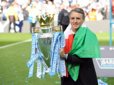 Mancini bersama trofi liga perdana yang dimenangi pasukan Man City musim lalu.