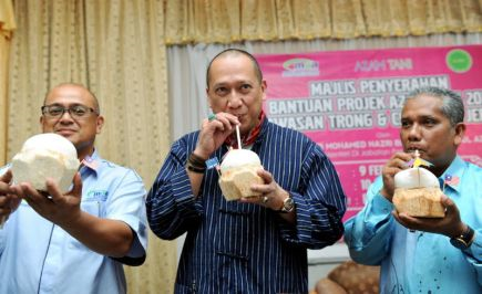 Menteri di Jabatan Perdana Menteri Datuk Seri Mohamed Nazri Abdul Aziz mencuba keenakan air kelapa muda ketika hadir pada program penyampaian Bantuan Azam Tani (fasa1) di Seratak Anjung Resort, Kuala Terong di Taiping, pada Sabtu.Turut hadir Adun Terong Datuk Rosli Husin (kanan) dan Pengarah Mardi Perak Dr Zabri Abd Wahid (kiri).-Foto BERNAMA