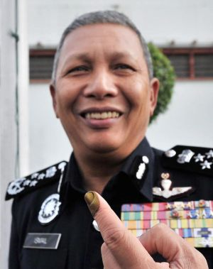 Ketua Polis Negara, Tan Sri Ismail Omar menunjukan jarinya yang telah dicalit dengan dakwat kekal selepas pengundian awal bagi Pilihan Raya Umum Ke-13 (PRU13) di Ibu Pejabat Polis Bukit Aman.-Foto BERNAMA