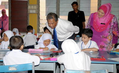 Timbalan Perdana Menteri Tan Sri Muhyiddin Yassin melihat murid-murid Tahun Satu semasa proses pembelajaran ketika membuat lawatan ke Sekolah Kebangsaan Alam Megah (2), di Seksyen 27, Shah Alam, Khamis.  Turut hadir Guru Besar SK Alam Megah (2), Ros Aini Che Man (kanan).   -fotoBERNAMA