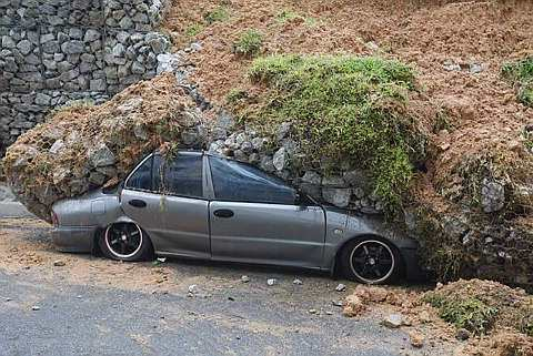 Tiga kereta dan sebuah motosikal tertimbus di bawah tanah. Foto THE STAR oleh CHAN TAK KONG