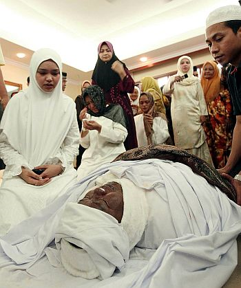 Siti Nurhaliza (kiri) memberi penghormatan terakhir kepada bapanya Allahyarham Tarudin Ismail sebelum solat jenazah di Bukit Antarabangsa di sini, semalam - foto oleh BERNAMA